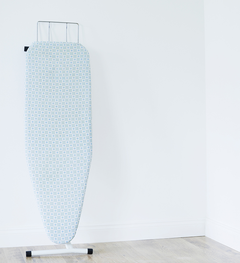Ironing board against white wall