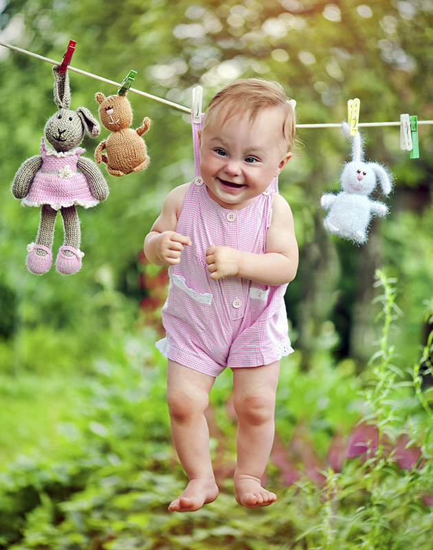 Cute baby girl hanging on the rope